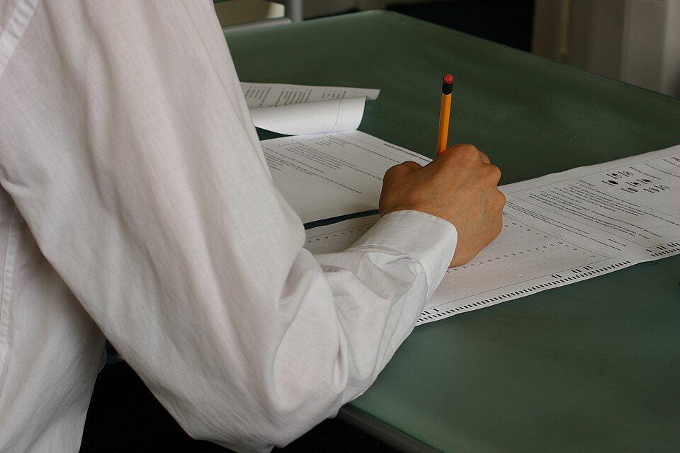 Étudiant rédigeant une copie d'examen en classe